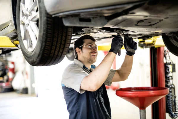 Bonito trabalho mecânico em uniforme trabalhando no carro — Fotografia de Stock