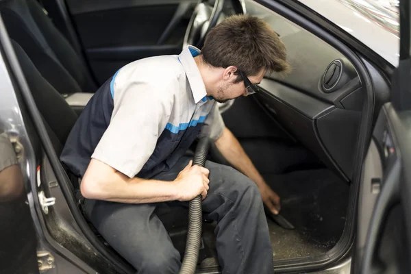 Mecânico aspirando o carro na garagem — Fotografia de Stock