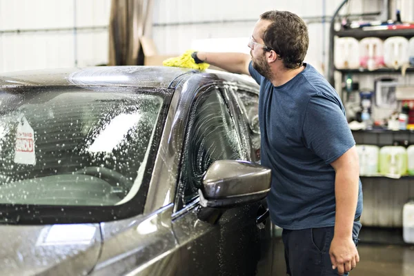 Homem no trabalho limpeza automóvel na lavagem de carro — Fotografia de Stock