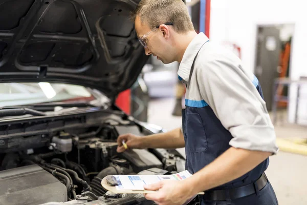 Przystojny mechanik praca w mundurze pracy na samochód — Zdjęcie stockowe