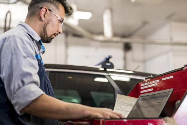 Przystojny mechanik praca w mundurze pracy na samochód — Zdjęcie stockowe