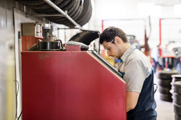 Schöner Mechaniker-Job in Uniform, der auf Autoteil arbeitet — Stockfoto