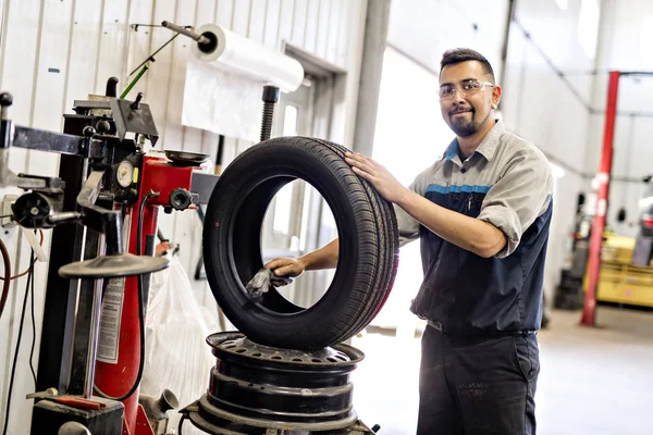 Mechanik mění auto pneumatiky při práci — Stock fotografie