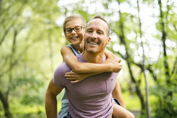 Father giving his son a piggyback ride, having fun — Stock Photo, Image