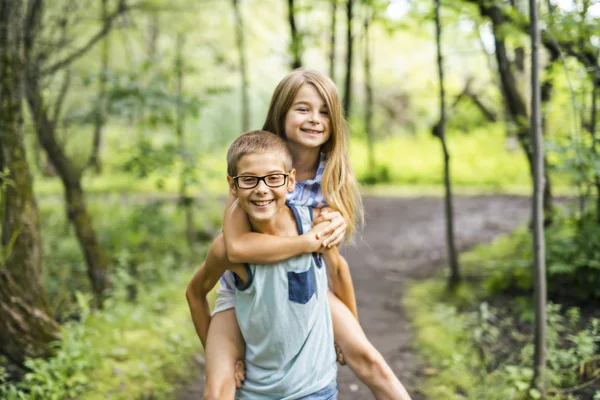 Bror och syster ger kombitrafik i skogen — Stockfoto