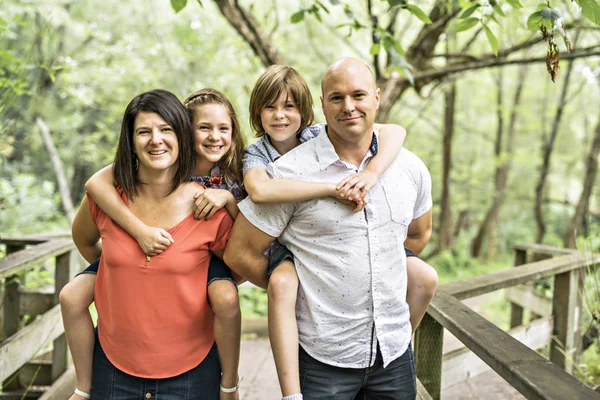 Mutlu genç aile birlikte eğleniyor ormandaki — Stok fotoğraf