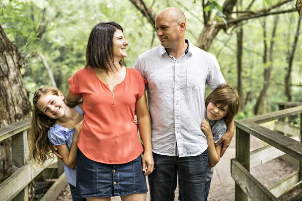 Feliz jovem família na floresta se divertindo juntos — Fotografia de Stock