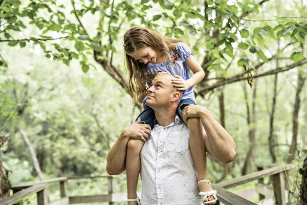 Father having fun in forest with his daughter on his shoulder — Stock Photo, Image