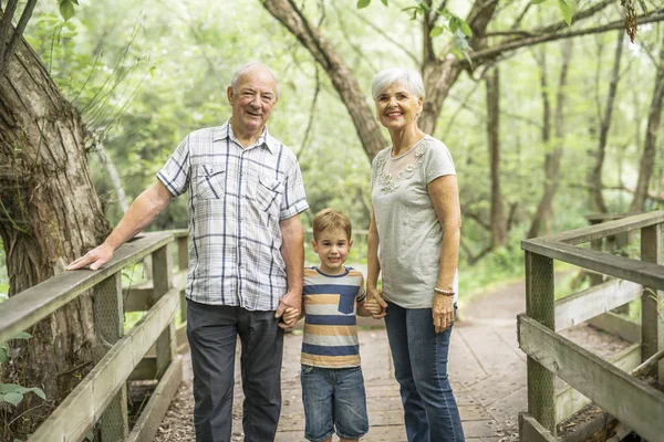 Grandparents with grandkid on summer forest having great time — Stock Photo, Image