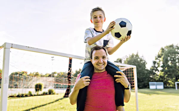 Mann mit Kind spielt draußen auf Feld Fußball — Stockfoto
