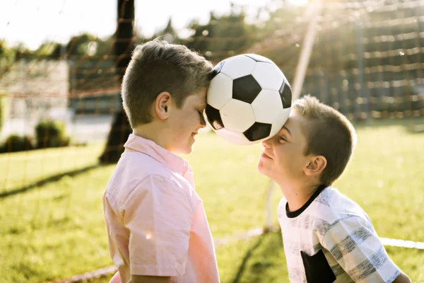 Meninos no parque de verão com uma bola de futebol — Fotografia de Stock