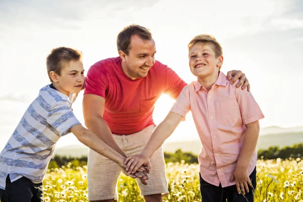 Vader tijd doorbrengen met twee zonen tijdens de zonsondergang. — Stockfoto