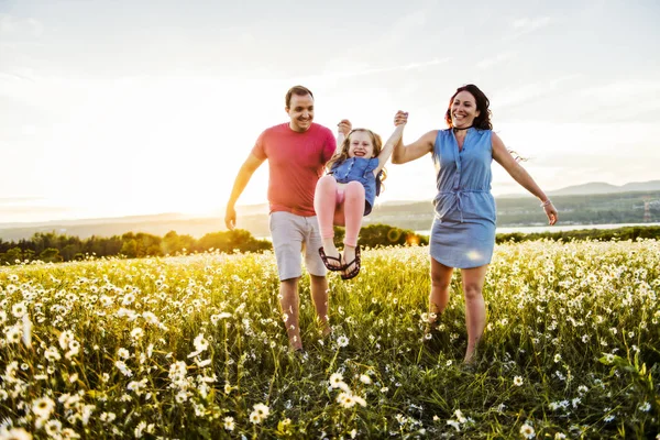 Familie tijd buitenshuis doorbrengen samen vader, moeder en dochter zijn plezier tijdens de zonsondergang. — Stockfoto