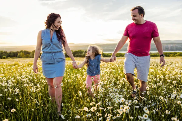 Family outdoors spending time together Father, mother and daughter are having fun during the sunset. — Stock Photo, Image