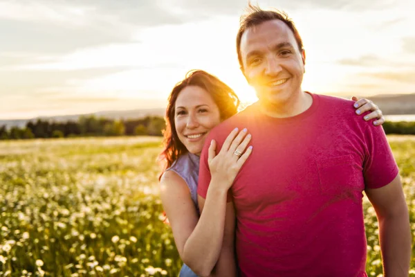 Мужчина и женщина на поле ромашки на закате — стоковое фото