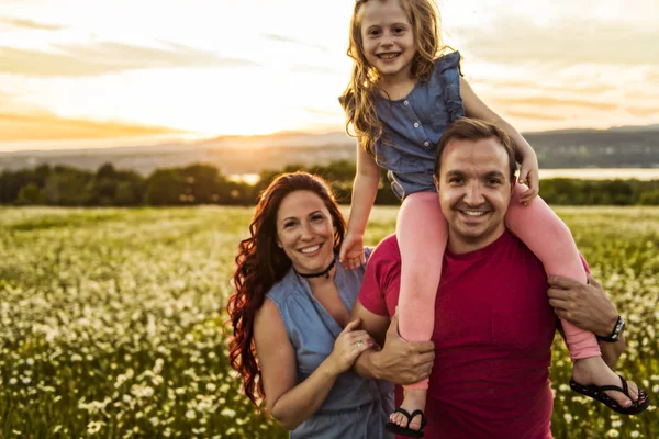 Familie tijd buitenshuis doorbrengen samen vader, moeder en dochter zijn plezier tijdens de zonsondergang. — Stockfoto