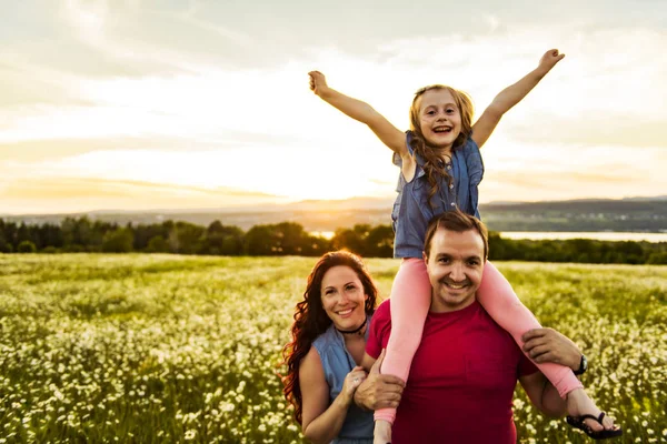 屋外の時間を過ごす家族の父、母と娘が一緒に楽しんでいる、日没時に. — ストック写真