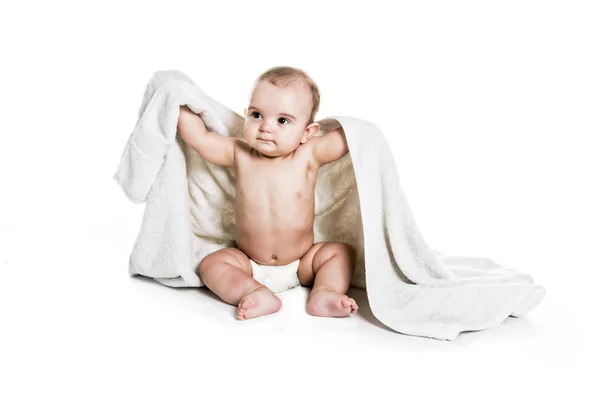 Portrait de bébé garçon sur fond blanc avec serviette de bain au-dessus de sa tête — Photo