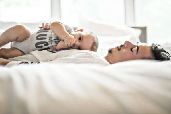 Padre y adorable bebé en la cama — Foto de Stock