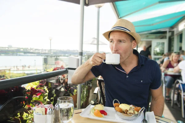 Молодой человек сидит турист сидеть на завтрак с кофе — стоковое фото
