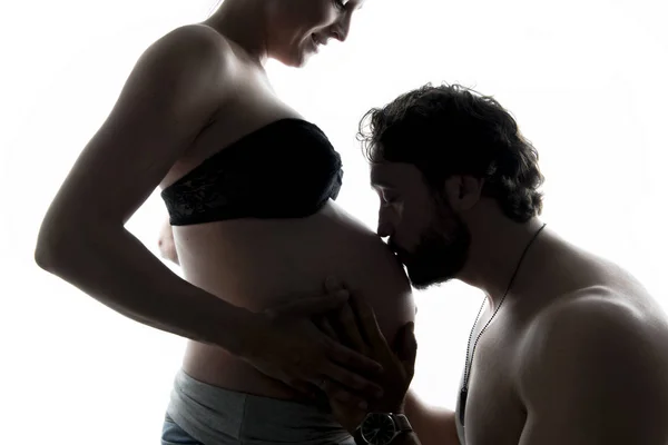 Gegen das helle Porträt eines schwangeren Paares — Stockfoto