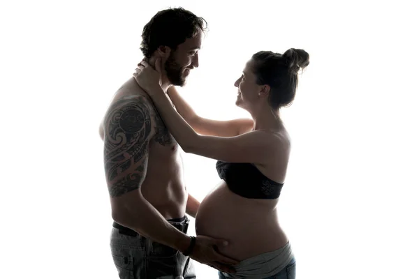 Gegen das helle Porträt eines schwangeren Paares — Stockfoto
