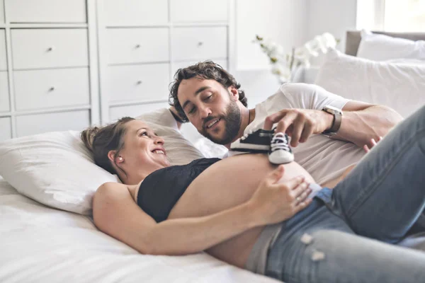 Мужчина с беременной женщиной в постели дома отлично проводит время — стоковое фото