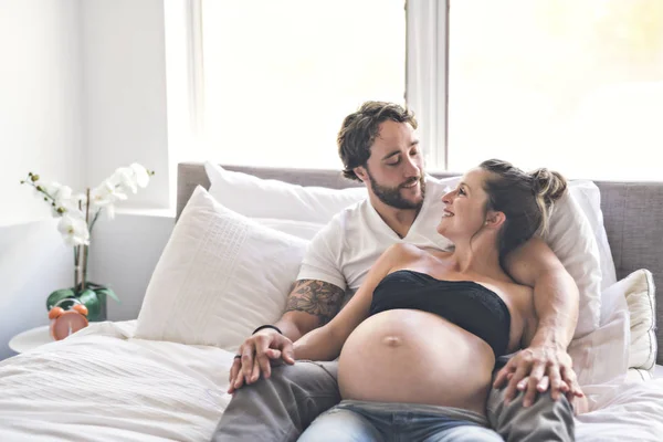 Mężczyzna z kobietą w ciąży w łóżku w domu o wielki czas — Zdjęcie stockowe