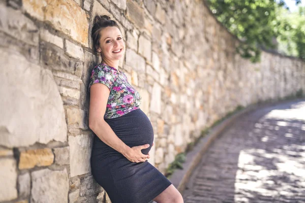 Retrato de una mujer embarazada feliz y orgullosa sobre fondo urbano —  Fotos de Stock