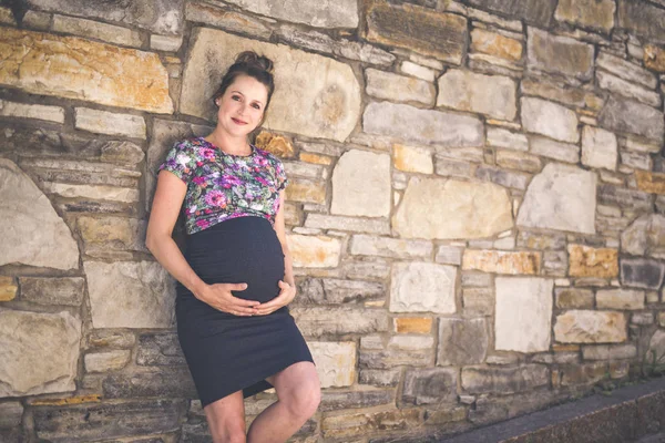 Porträt einer glücklichen und stolzen Schwangeren vor städtischem Hintergrund — Stockfoto