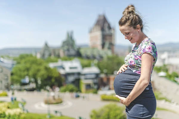 Retrato de una mujer embarazada feliz y orgullosa sobre fondo urbano —  Fotos de Stock