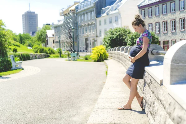 Retrato de una mujer embarazada feliz y orgullosa sobre fondo urbano —  Fotos de Stock