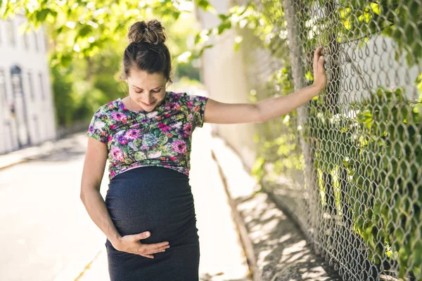 Retrato de una mujer embarazada feliz y orgullosa sobre fondo urbano —  Fotos de Stock