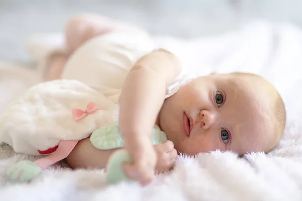 Bedårande två månader baby flicka avkopplande i sovrum på stickad filt på en solig morgon — Stockfoto