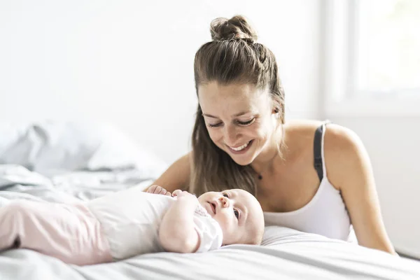 Портрет красивої матері з її 2-місячною дитиною в спальні — стокове фото