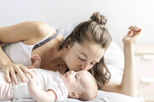 Retrato de una hermosa madre con su bebé de 2 meses en el dormitorio — Foto de Stock