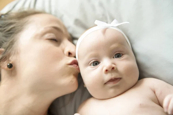 Portrait of a beautiful mother with her 2 month old baby in the bedroom — Stock Photo, Image