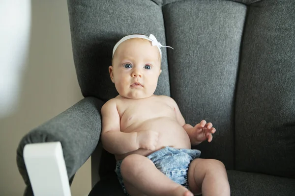 Adorabile bambina di due mesi che si rilassa sulla sedia della camera da letto in una mattina di sole — Foto Stock