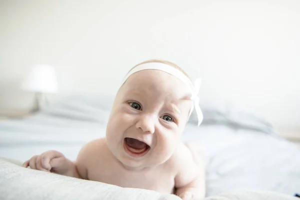 Αξιολάτρευτο δύο μηνών μωρό κορίτσι χαλάρωση στο υπνοδωμάτιο στο πλεκτό κουβέρτα σε ένα ηλιόλουστο πρωί — Φωτογραφία Αρχείου