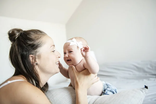 Retrato de una hermosa madre con su bebé de 2 meses en el dormitorio — Foto de Stock