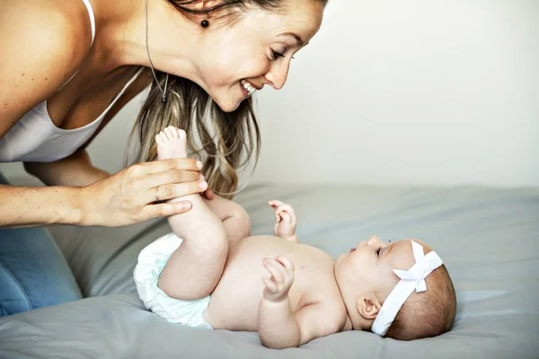 Retrato de una hermosa madre con su bebé de 2 meses en el dormitorio — Foto de Stock