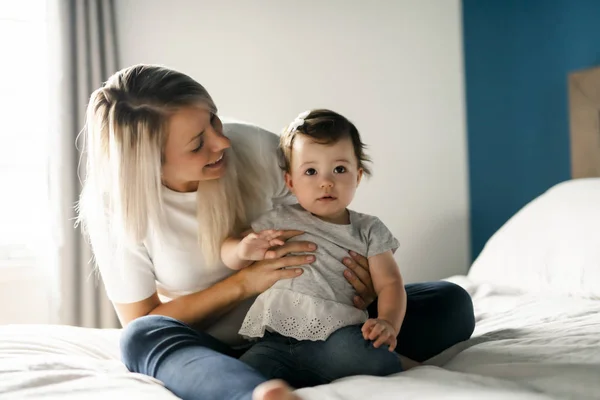 Madre jugando con bebé hija en el dormitorio en casa — Foto de Stock