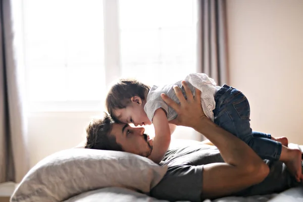 Young father with child girl on bed at home — Stock Photo, Image