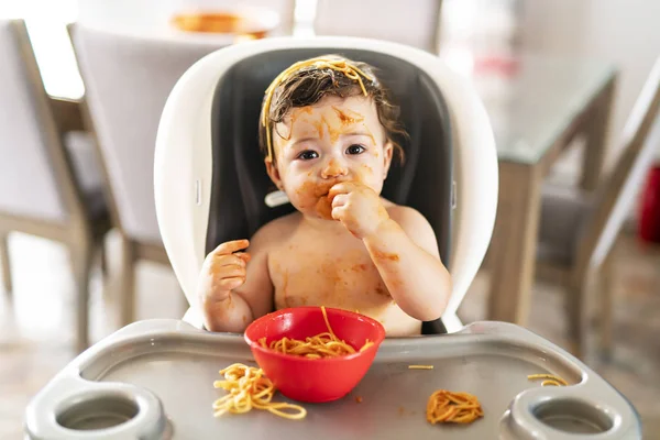 子供の頃、昼食にスパゲティを食べ、キッチンで家で混乱を作る — ストック写真
