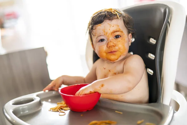 Niña, comer espaguetis para el almuerzo y hacer un lío en casa en la cocina — Foto de Stock