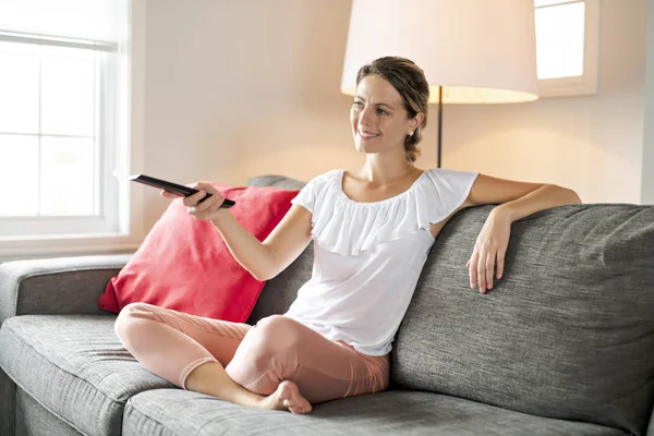 Mujer joven viendo la televisión en la sala de estar —  Fotos de Stock