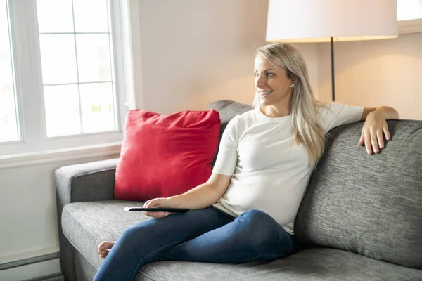 Mujer joven viendo la televisión en la sala de estar — Foto de Stock
