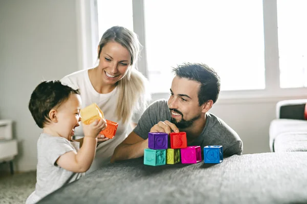 Pai feliz, mãe e filha brincando com blocos de brinquedo em casa — Fotografia de Stock