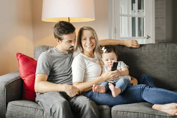 Familia madre, padre, hija en casa viendo la televisión — Foto de Stock