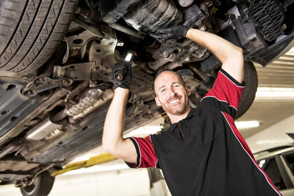 Gutaussehender Mechaniker mit Auto in der Autowerkstatt — Stockfoto